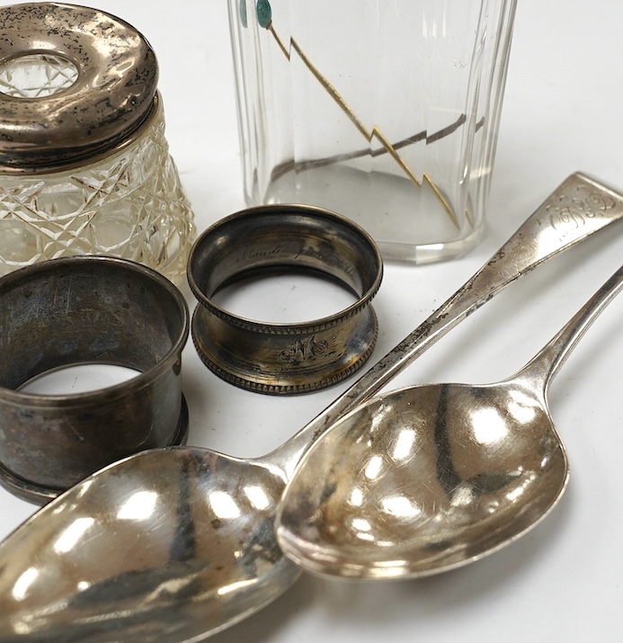 Two George III provincial silver Exeter table spoons, 22cm, two silver napkin rings and two silver mounted glass toilet jars. Condition - poor to fair